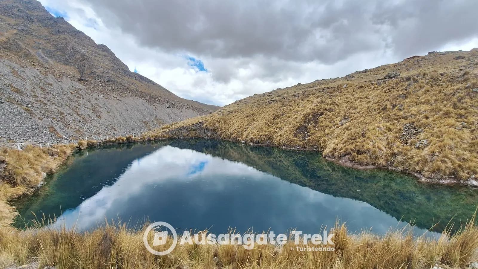 Dark teal Orqo Uturunku Qocha reflecting the sky on the Ausangate 7 Lakes hike